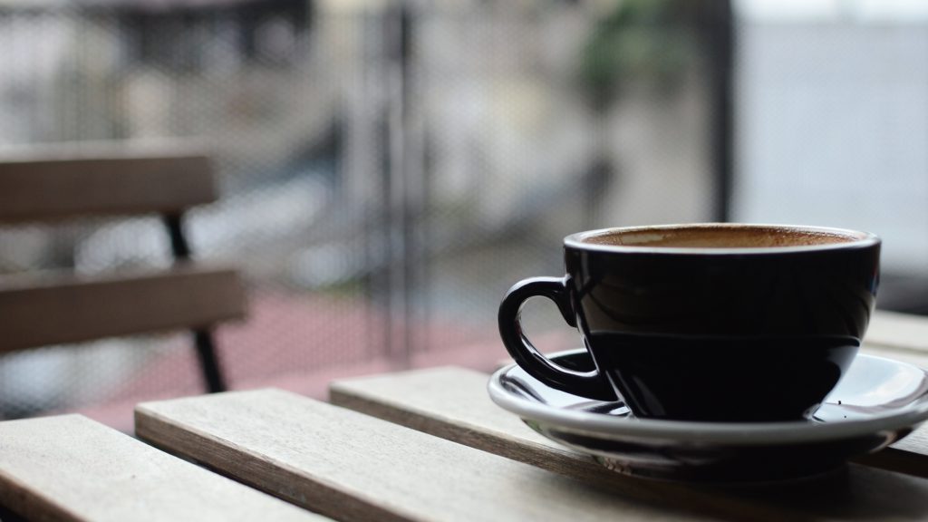 Ein Kaffee steht auf dem Bistrotisch